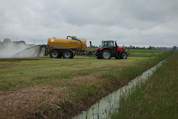 Foto: Marion Ruppaner Ein Traktor verteilt auf einer Wiese Gülle neben einem Wasserlauf. Durch zu viel Gülle erhöhen sich die Nitratwerte im Grundwasser. (Foto: Marion Ruppaner)