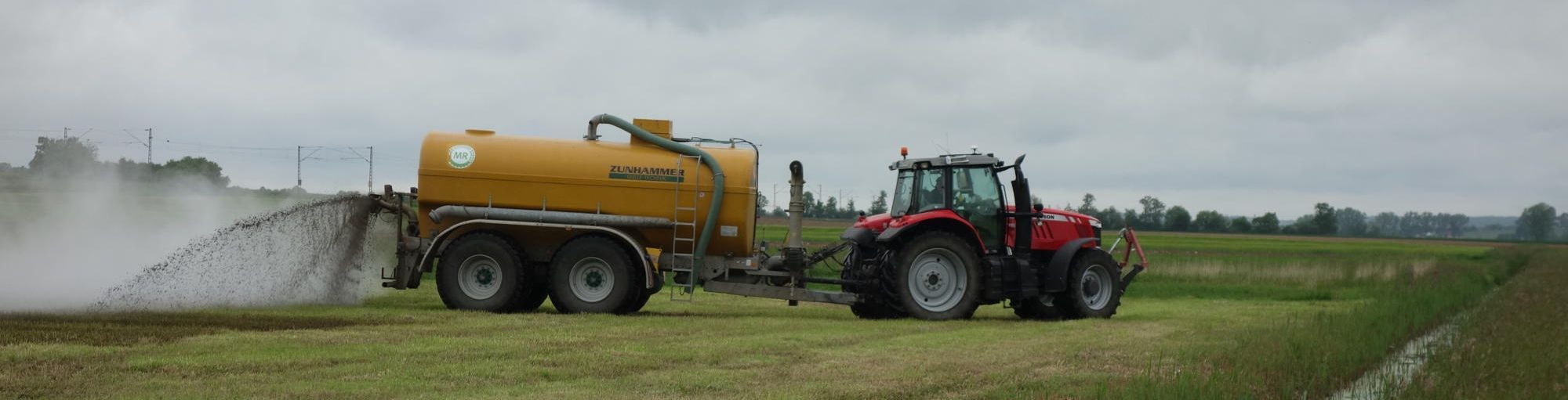 Nitrat im Grundwasser: Dünger aus der Landwirtschaft spielt hier eine große Rolle (Foto: Marion Ruppaner) Nitrat im Grundwasser: Ein Traktor verteilt auf einer Wiese Guelle neben einem Wasserlauf