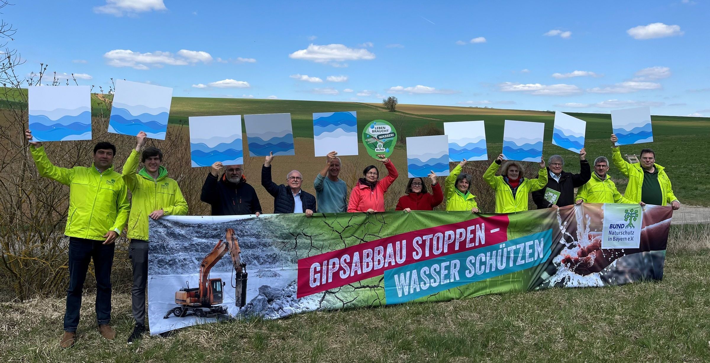 Gipsabbau stoppen - Wasser schützen! (Foto: BN) Der BN Vorstand steht an dem Ort, an dem das Bergwerk geplant ist und Hält ein Banner hoch, auf dem Gipsabbau stoppen - Wasser schützen! steht