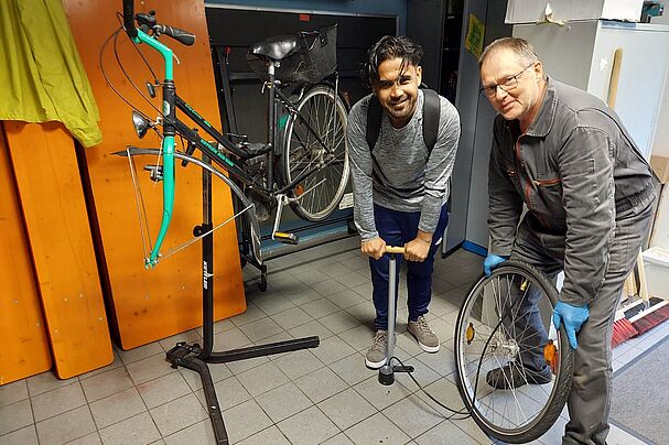 Gemeinsam mit dem Besitzer des Fahrrads setzt Bernhard Bröstler im Repair Café ein älteres Fahrrad instand, Foto Stephanie Namyslo