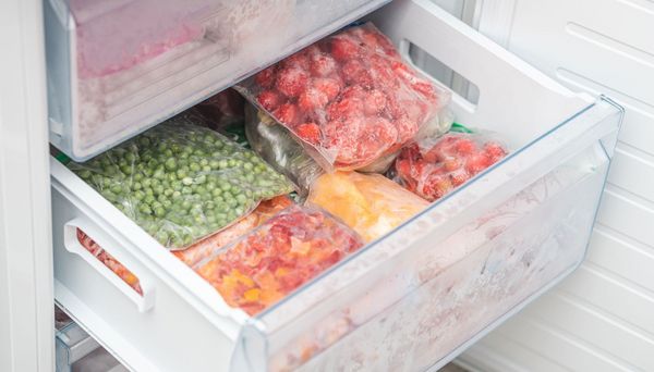 Lebensmittel konservieren: Lebensmittel einzufrieren geht besonders schnell und einfach, verbraucht aber vergleichsweise viel Energie. (Foto: Андрей К/stock.adobe.com) Lebensmittel konservieren: Beutel mit eingefrorenem Gemüse liegen im Fach einer Gefriertruhe.