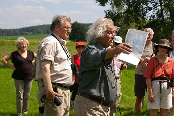 Klaus Arbter mit Hubert Weiger vor Zuhörerinnen auf einer Wiese