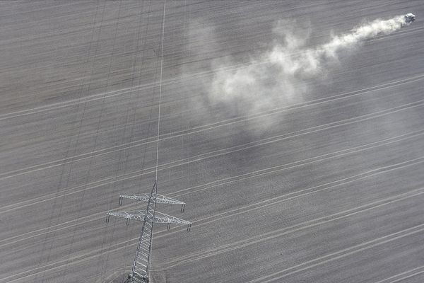 Kahler Ackerboden so weit das Auge reicht ohne Bäume oder Hecken, ein Traktor wirbelt Staub auf. Die heutige Agrarpolitik fördert solche großen Strukturen (Foto: Klaus Leidorf)