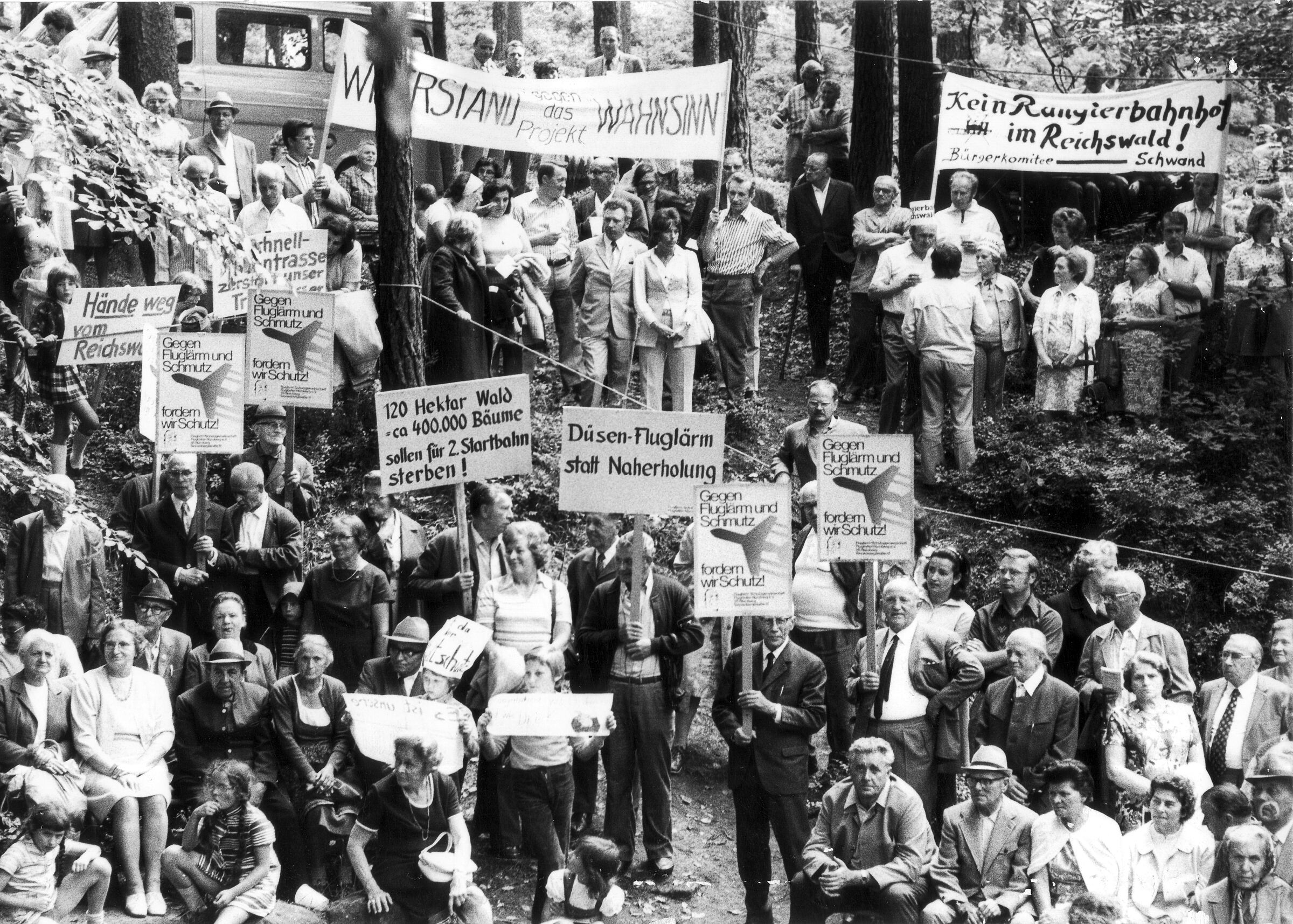 1973: Das erste Reichswaldfest wird am Schmausenbuck gefeiert (Foto: BN) Auf einem Schwarz-Weiß-Foto demonstrieren Menschen mit Bannern in einem Wald