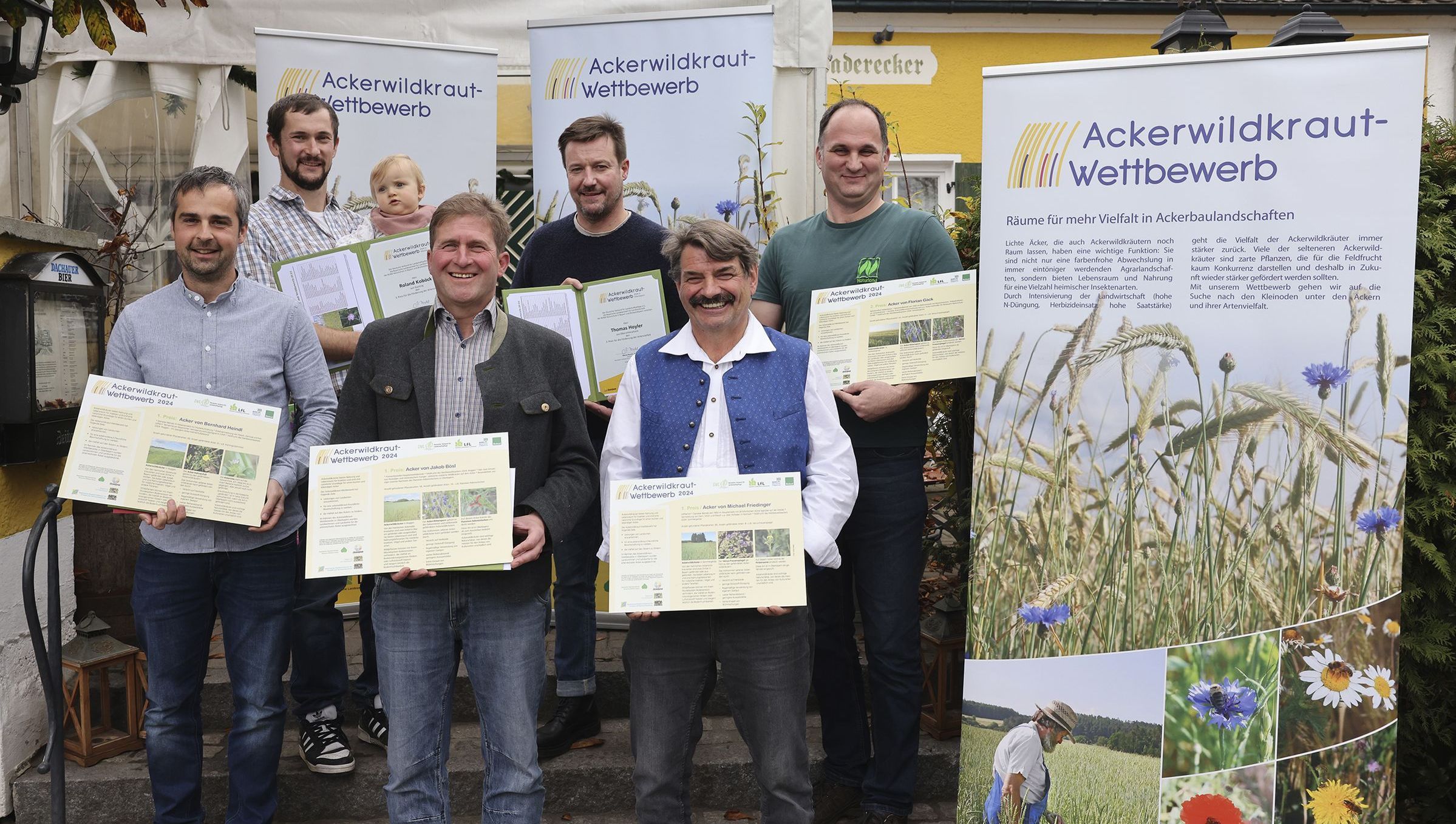 Die Preisträger des Ackerwildkraut-Wettbewerbs 2024: (v.li.) Bernhard Heindl (2. Preis), Roland Koböck (3. Preis), Jakob Bösl (1. Preis), Thomas Hoyler (3. Preis), Michael Friedinger (1. Preis), Florian Gäck (2. Preis) (Foto: Birgit Gleixner, LfL) Die Preisträger des Ackerwildkrautwettbewerbes 2024 vor Plakaten zum Ackerwildkraut-Wettbewerb (Foto: Birgit Gleixner, LfL)