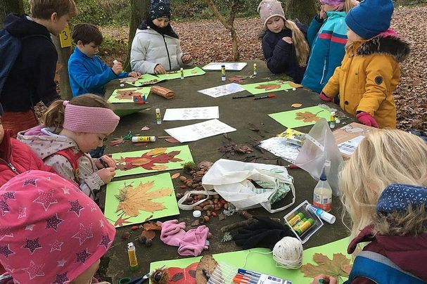 Kinder beim Basteln mit Herbstblättern, Foto Ulrich Geißler