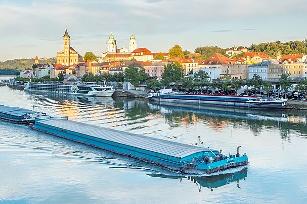 Ein großes Lastschiff passiert die Stadt Passau auf der Donau (Bild: AdobeStock/Animaflora PicsStock)